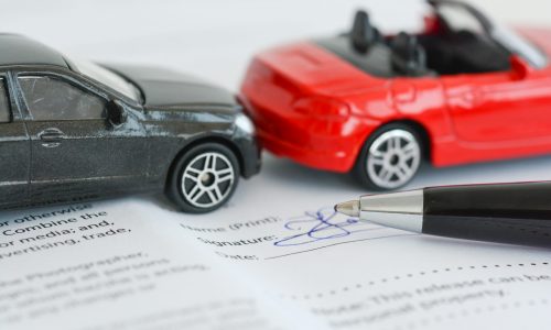Insurance policy contract concept with toy model cars having a crash or accident